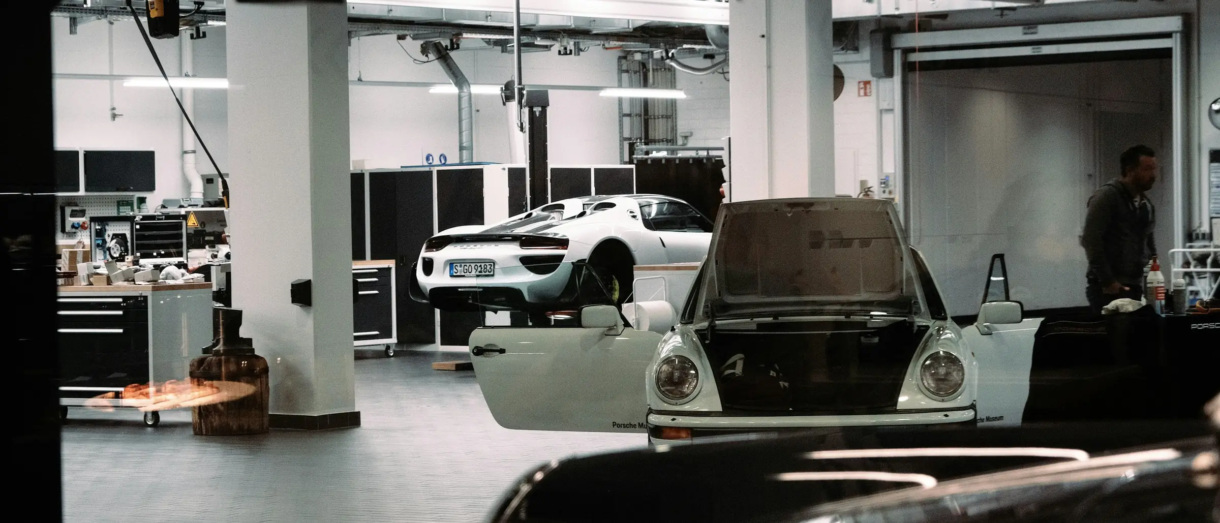 Wide view of a body repair workshop with several cars in various stages of repair